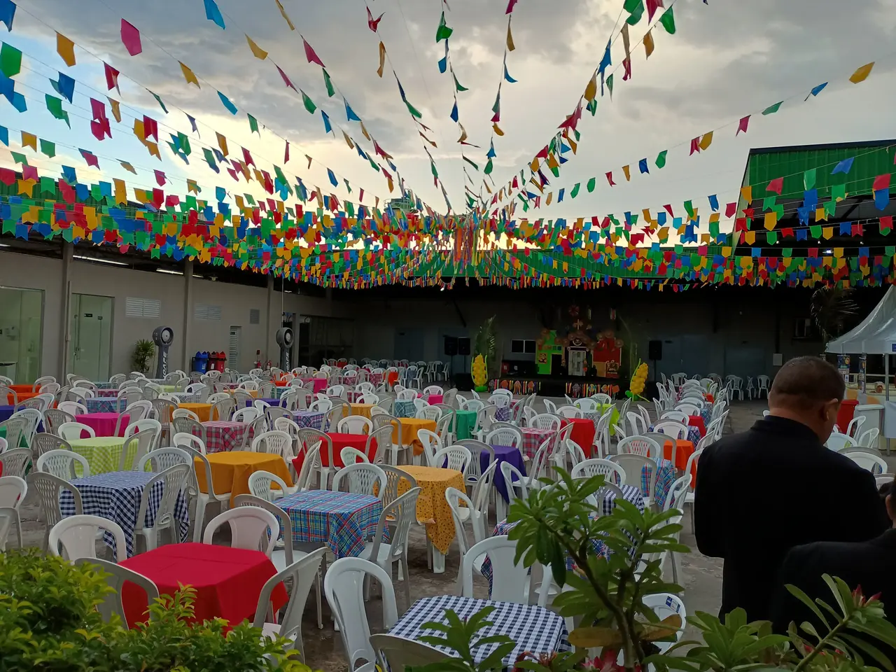 Mesas e cadeiras organizadas para uma festa com decoração junina